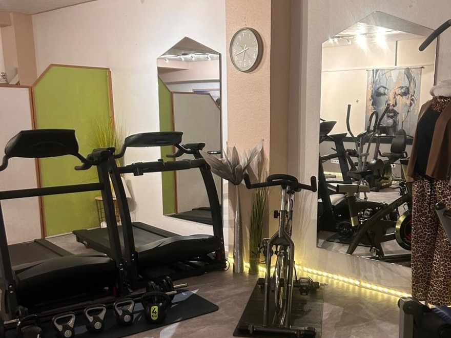 Der Geräteraum im Studio: Laufband, Fahrrad, Kleingeräte und Spiegel