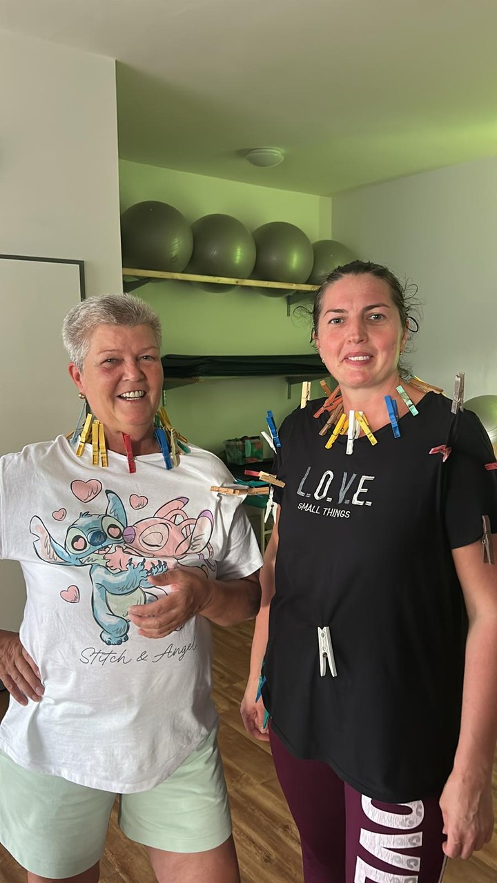 Zwei Kundinnen mit bunten Wäscheklammern am Shirt, beide lachen